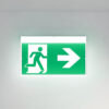Green emergency exit sign mounted on wall
